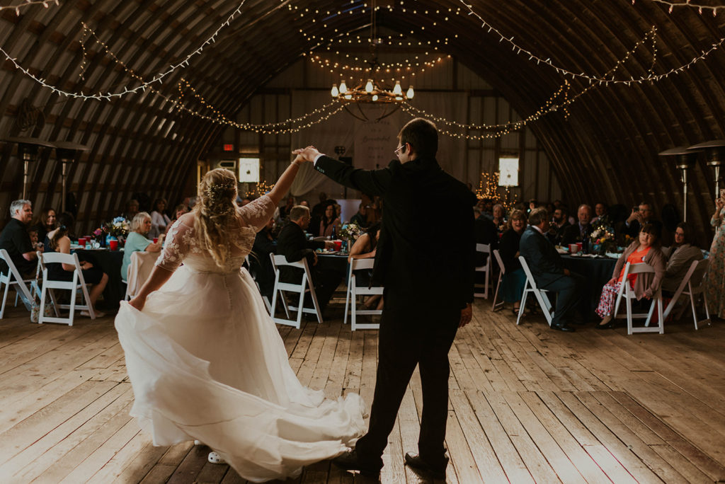 A couple is dancing at a wedding venue in Livingston County, facing the guests sitting in chairs.