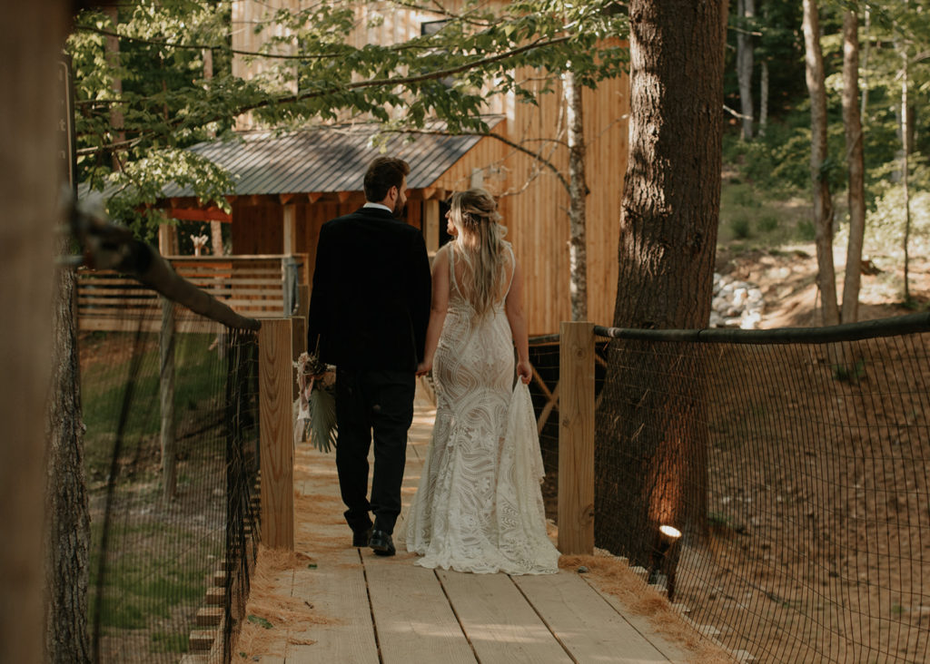 A couple walking towards a tree house in the Adirondacks, which is one of the best places to elope in New York!