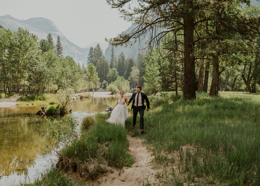 A couple walking down a trail during their destination wedding in Yosemite.
